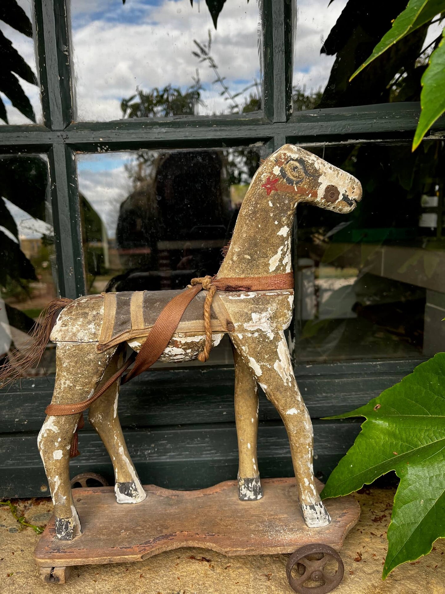 Cheval à bascule en bois posé sur rebord de fenêtre, ambiance brocante et déco champêtre