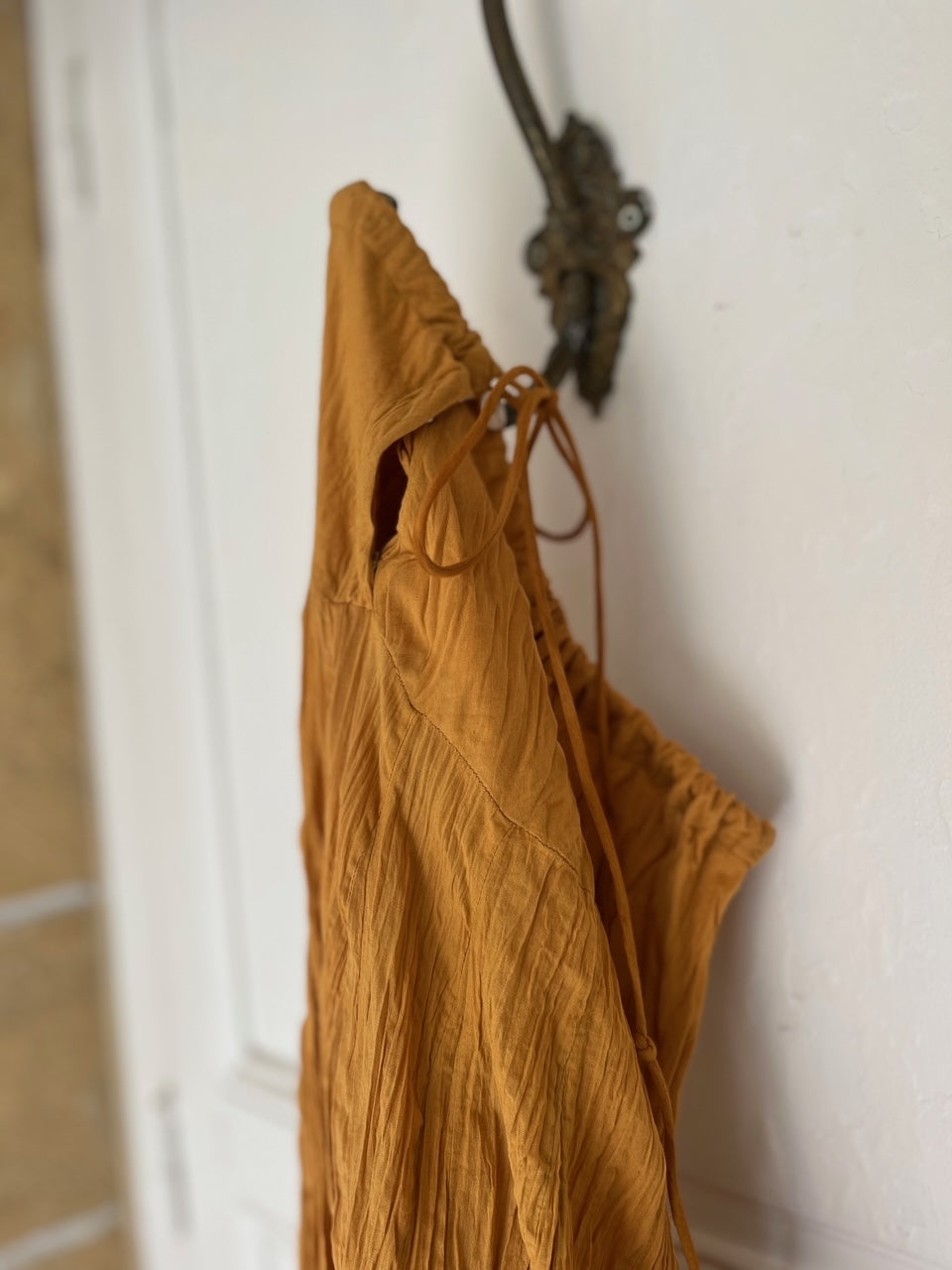 Détail de la taille nouée de la jupe jaune safran en coton, tissu léger