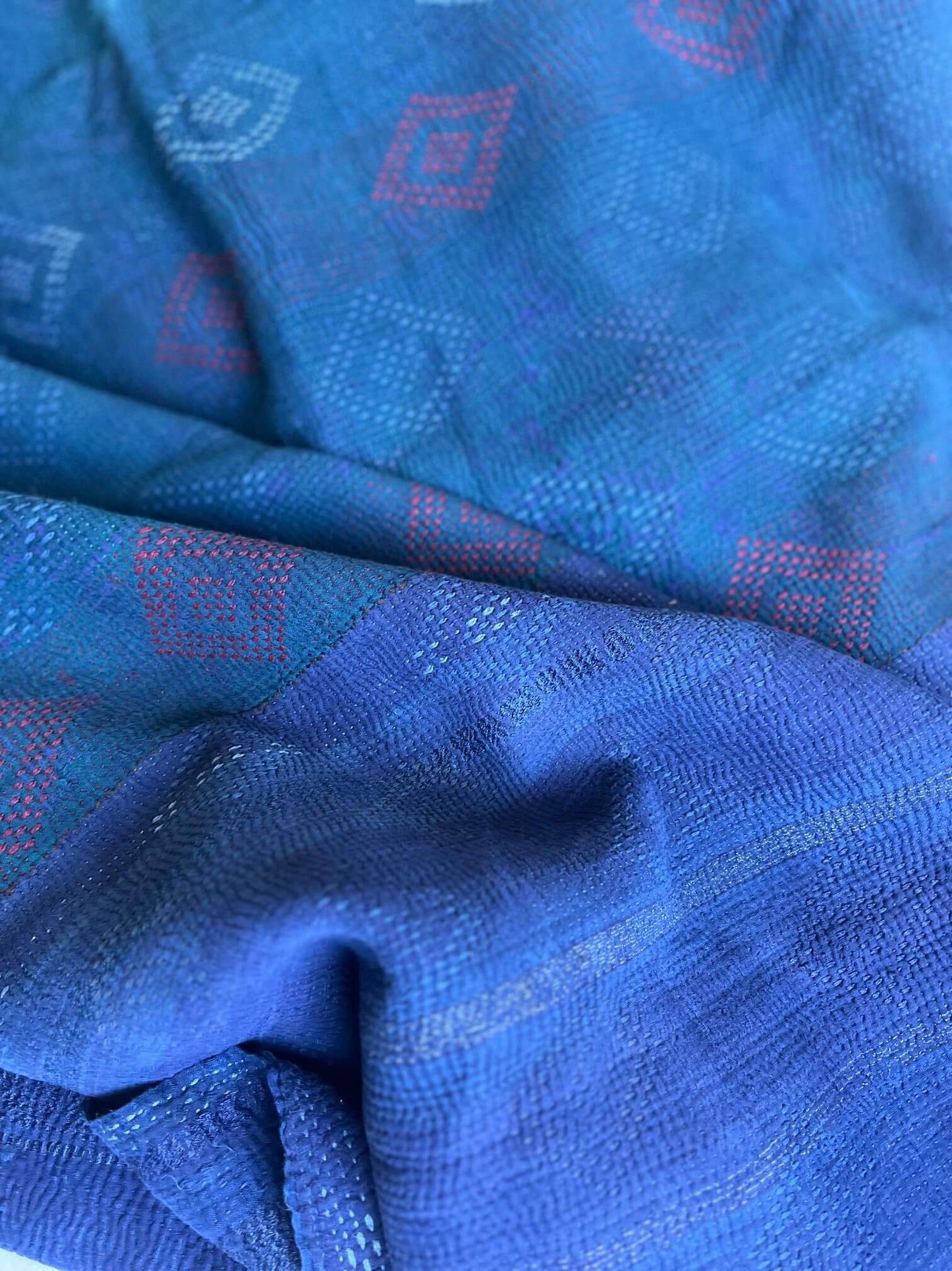 Détail des motifs brodés du kantha indien, indigo profond et touches de vert, couture traditionnelle kantha