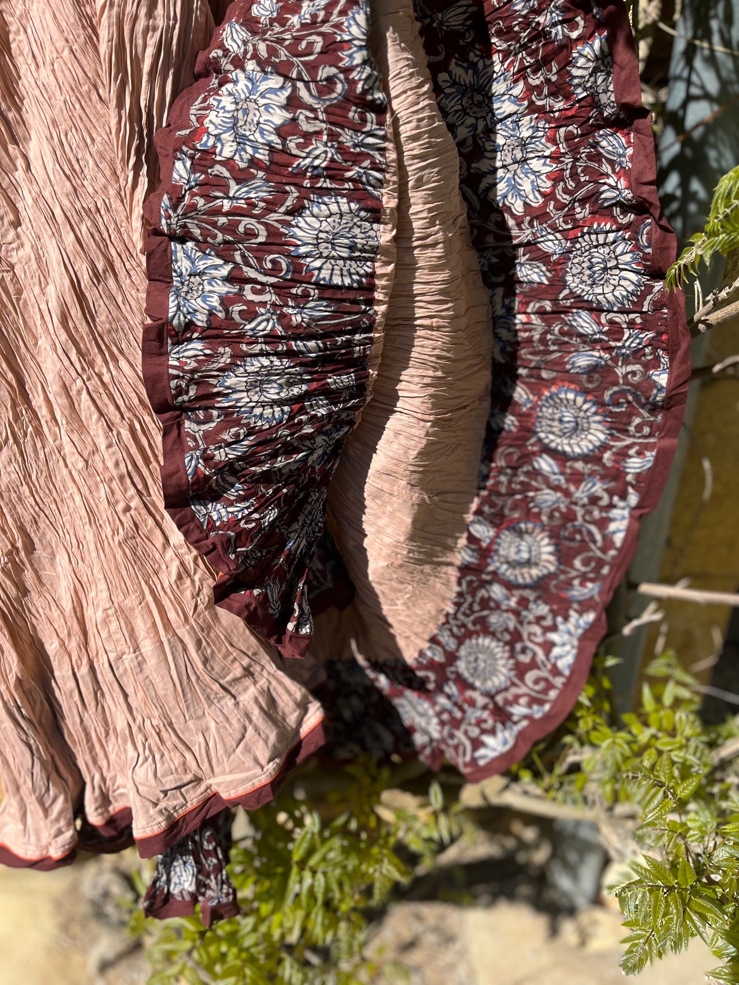 Intérieur fleuri de la jupe visible au mouvement – contraste entre tissu uni et motifs floraux