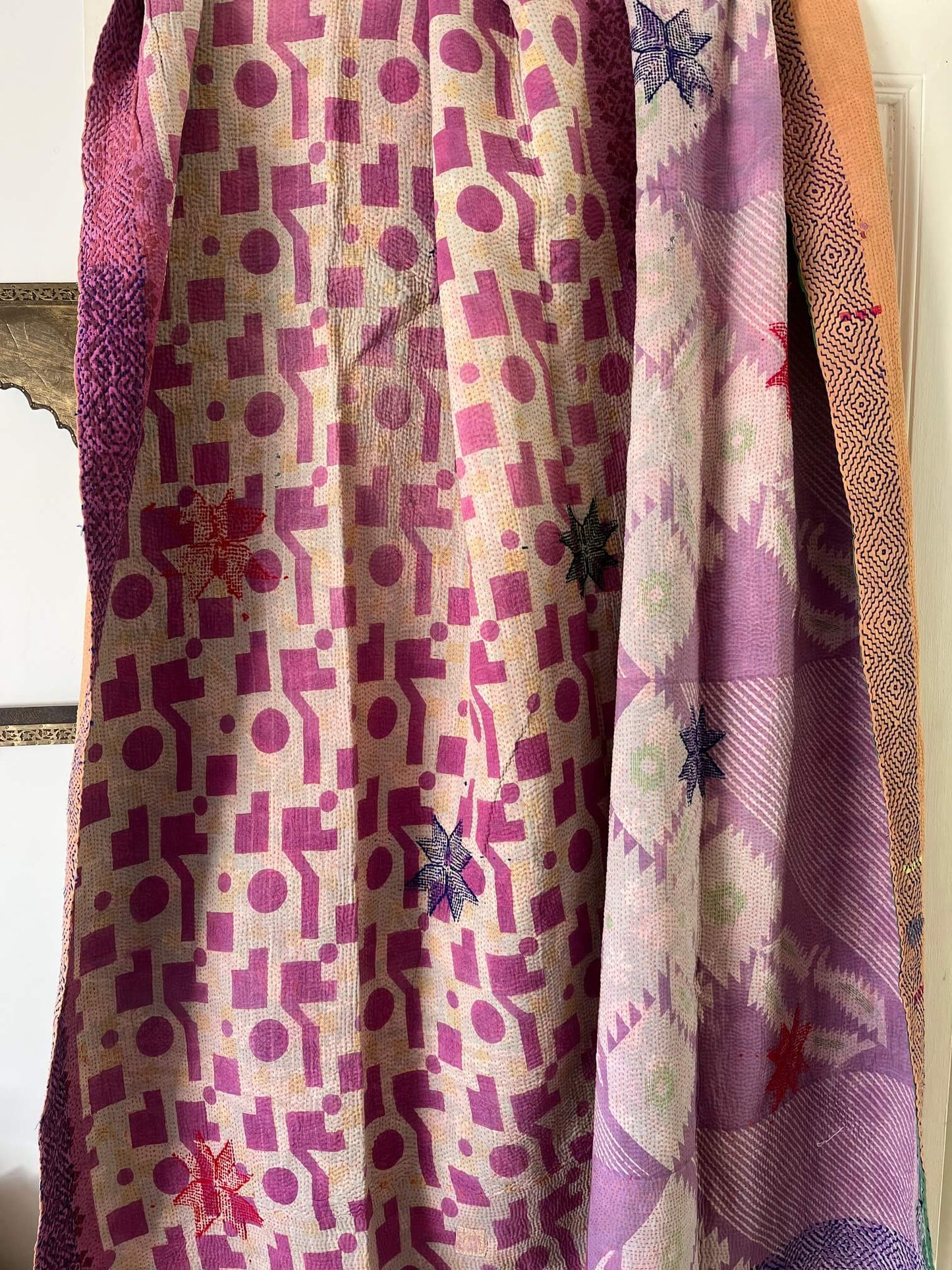 Côté verso du couvre-lit kantha, tissu vieux rose et broderies étoilées sur fond pêche
