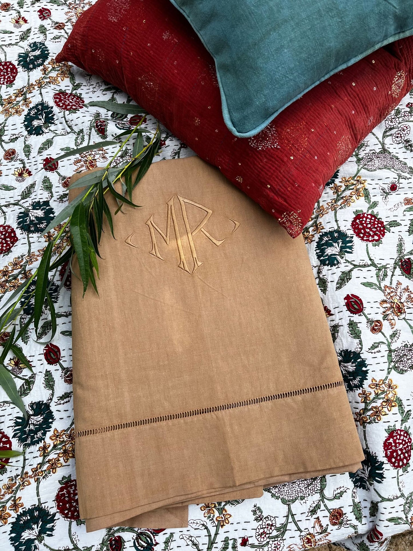 Drap vintage beige brodé MR accompagné de coussins colorés