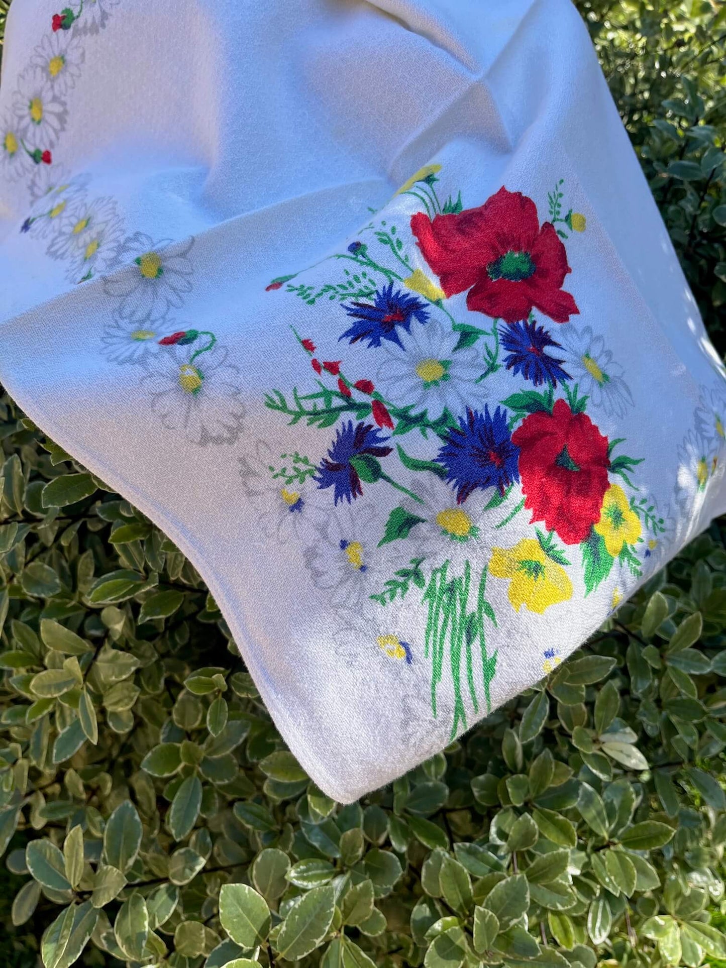 Gros plan sur un motif de coquelicots et bleuets imprimé sur une serviette vintage en coton