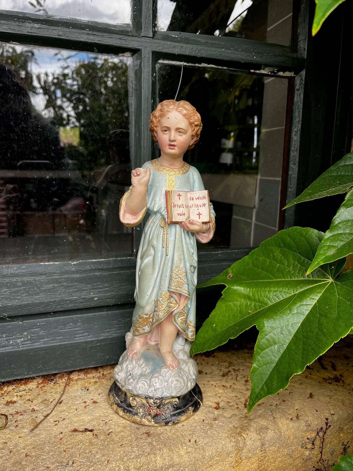 Détail du visage de l’Enfant Jésus en plâtre, objet ancien religieux patiné