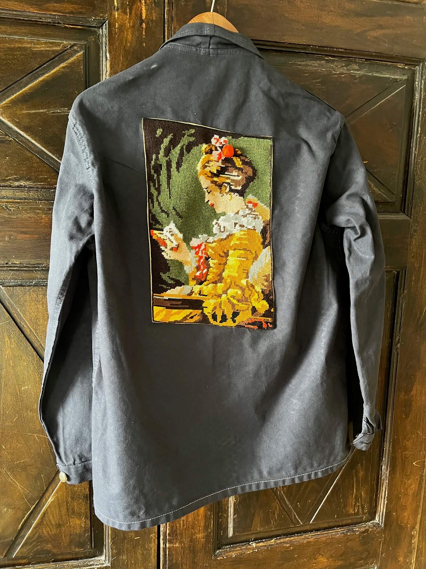 Détail de la broderie ancienne au point de croix sur le dos de la veste
