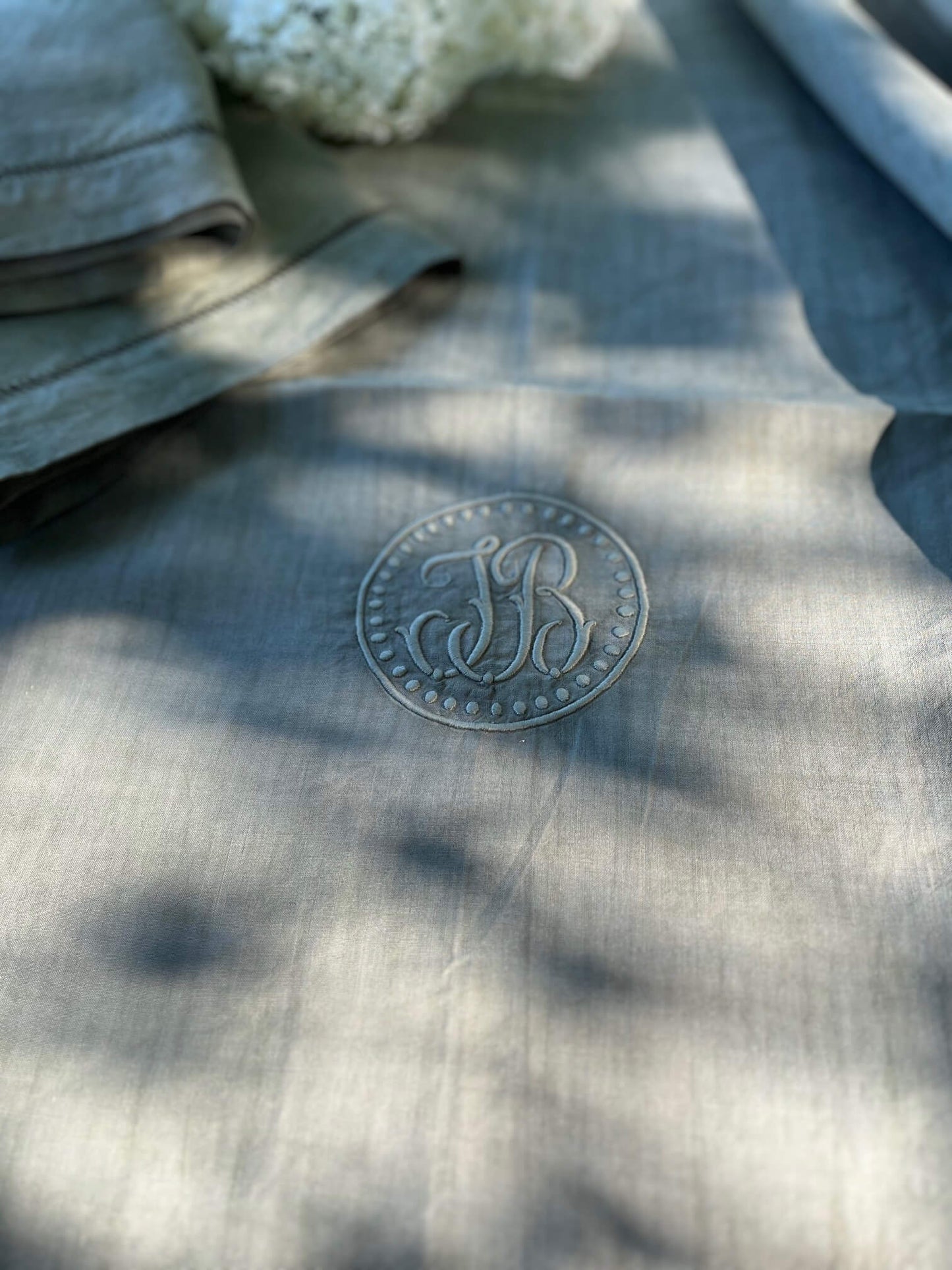 Zoom sur monogramme brodé "JB" sur drap ancien en lin