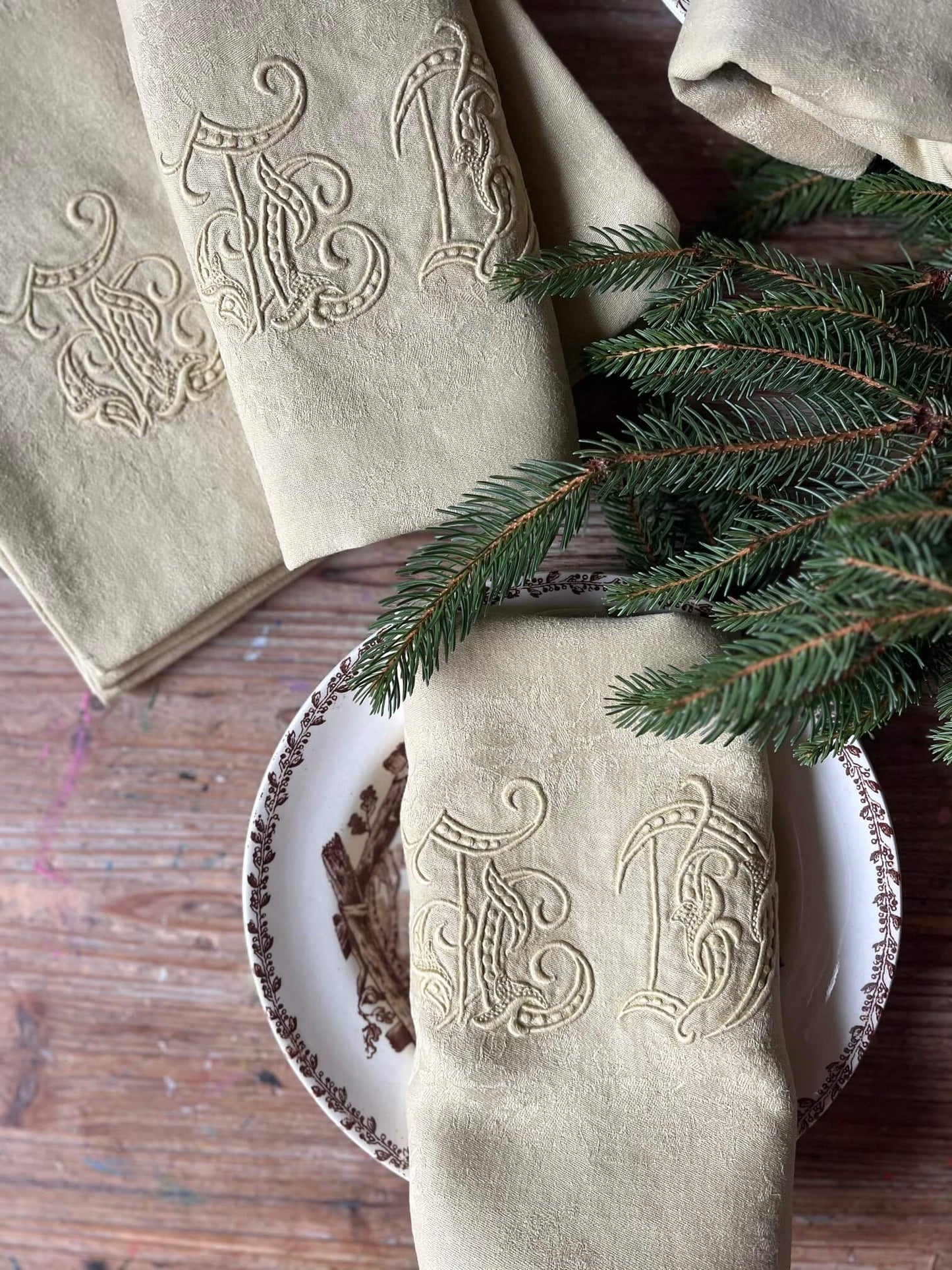  Gros plan sur serviettes anciennes ocre avec monogramme LD et petits trous, coton damassé