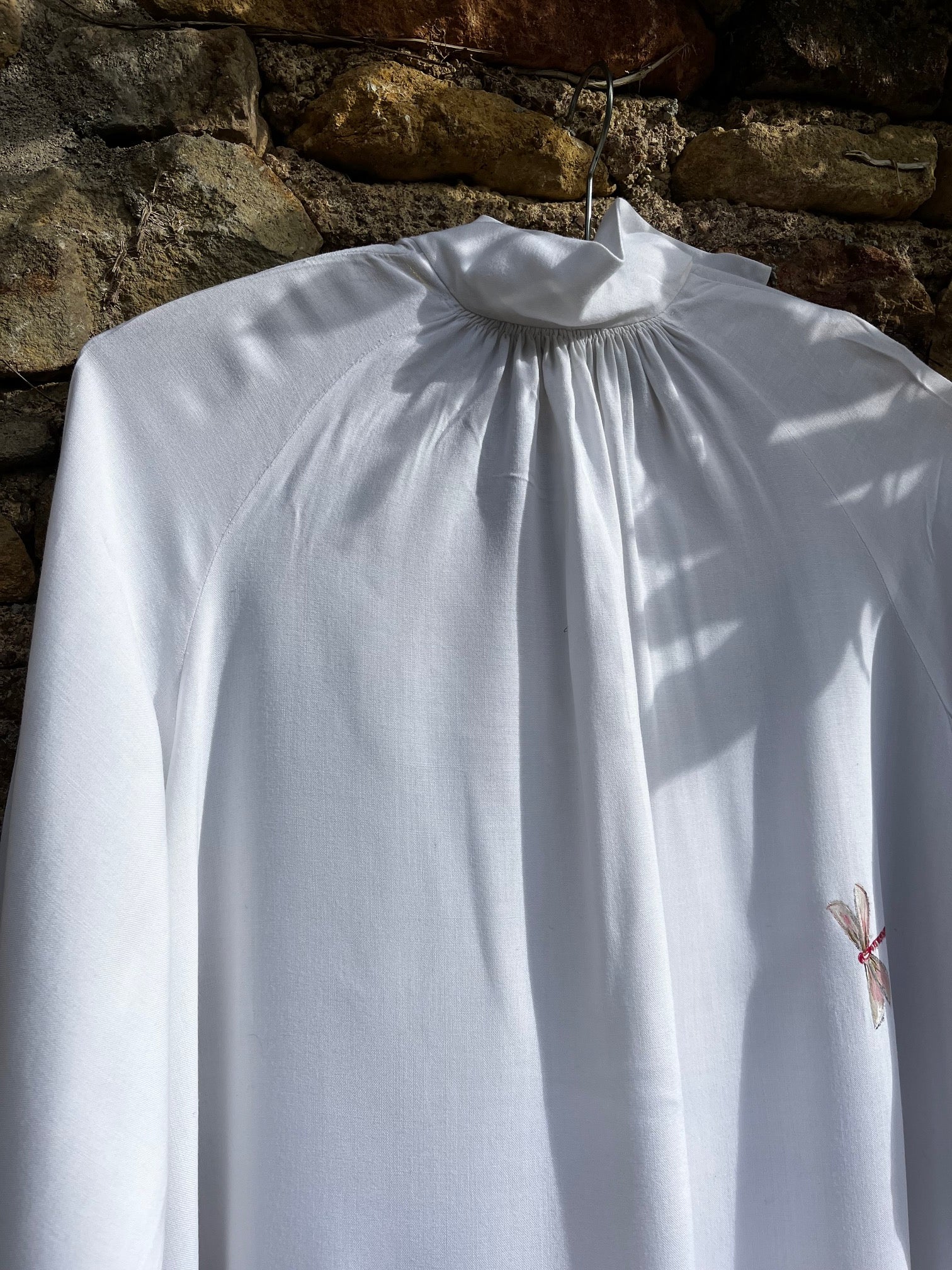 Détail peinture à la main sur aube ancienne en coton et lin