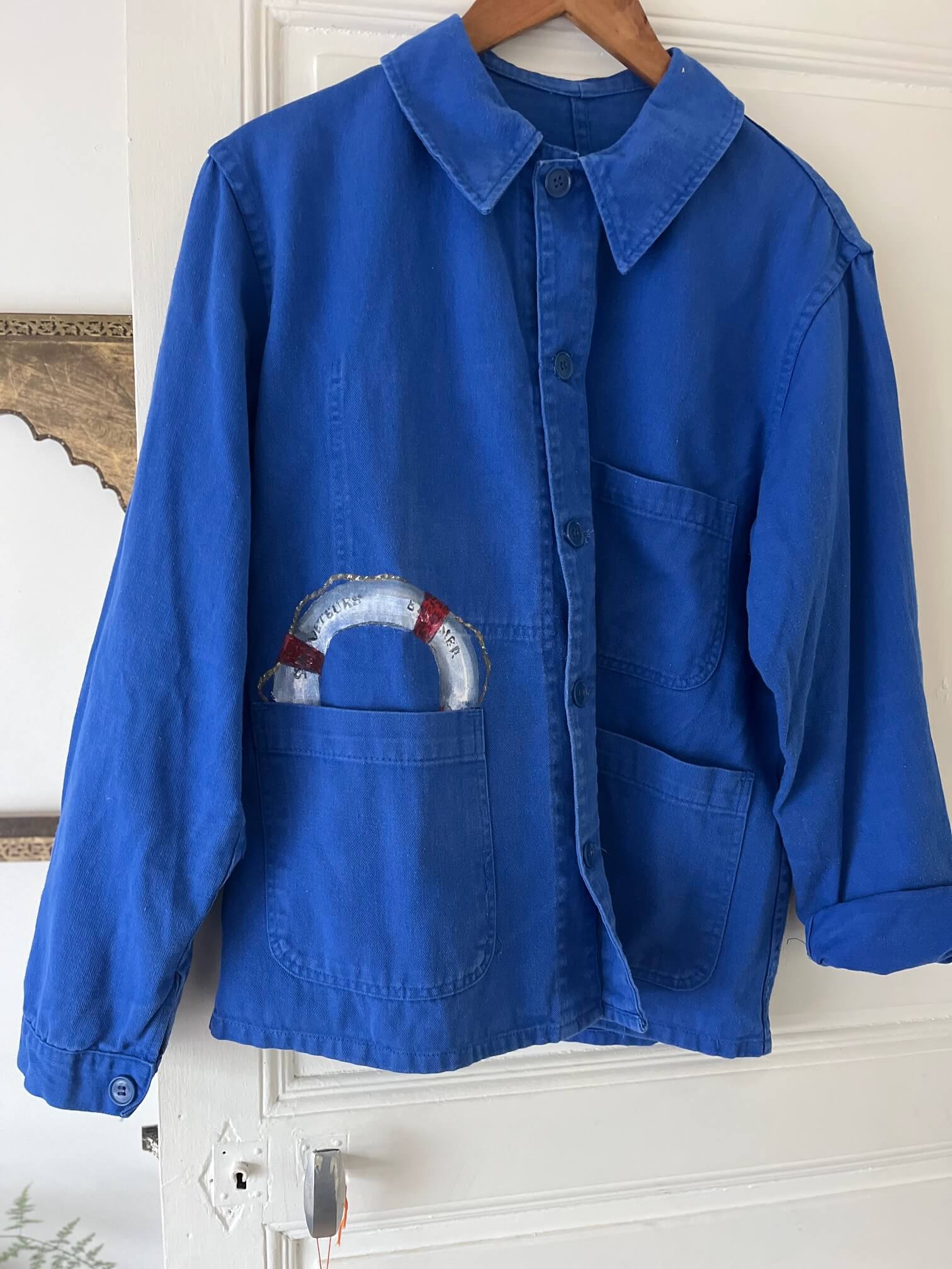 Détail peinture artisanale sur veste bleu de travail marin vintage