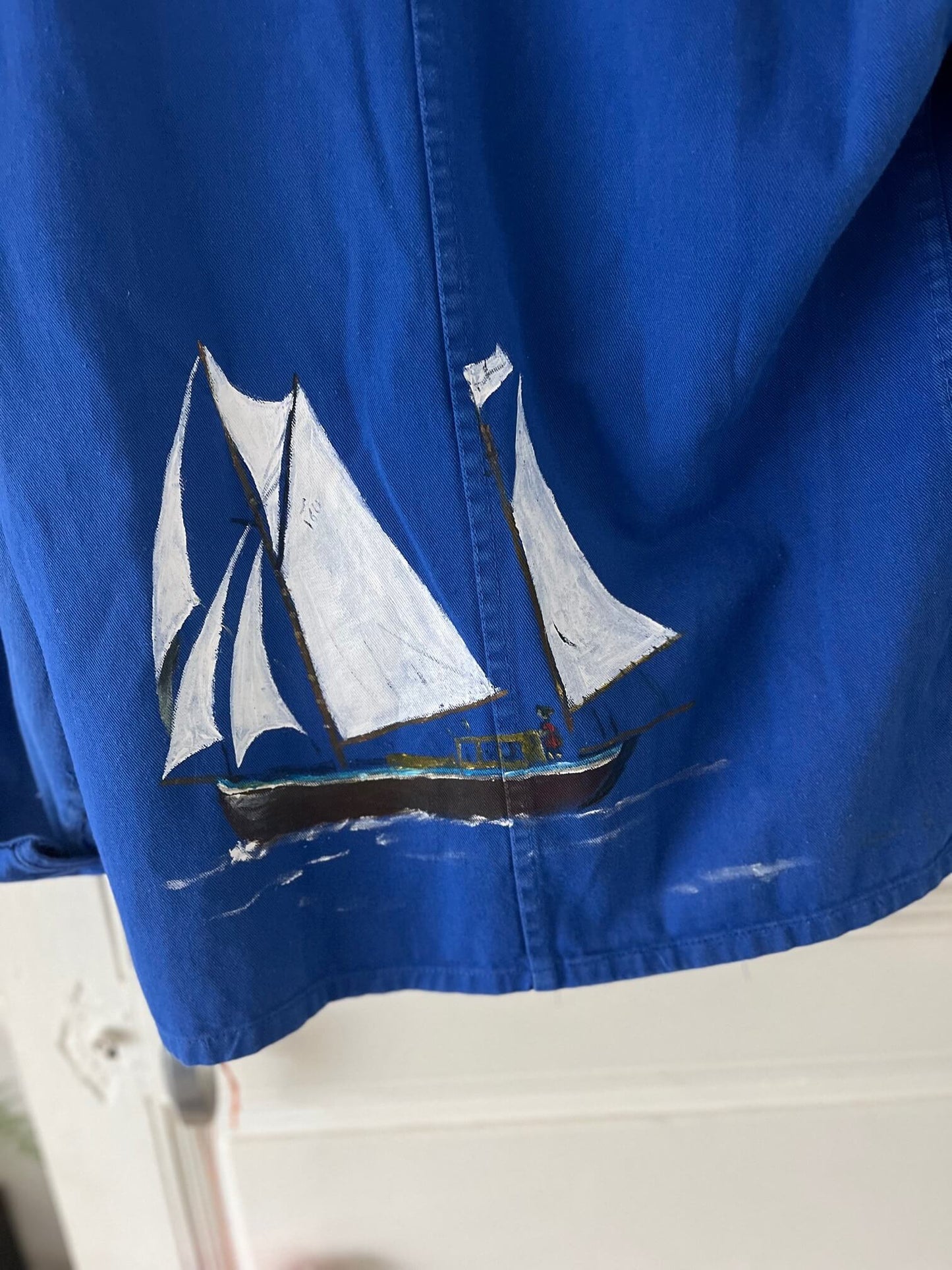 Zoom sur le tissu et la couture de la veste bleu de travail marin vintage, artisanat français