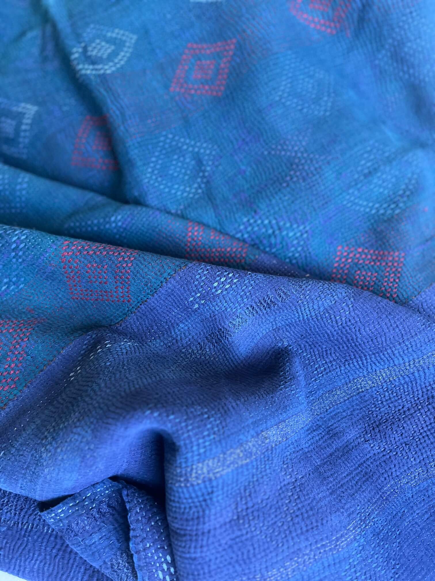 Détail des motifs brodés du kantha indien, indigo profond et touches de vert, couture traditionnelle kantha