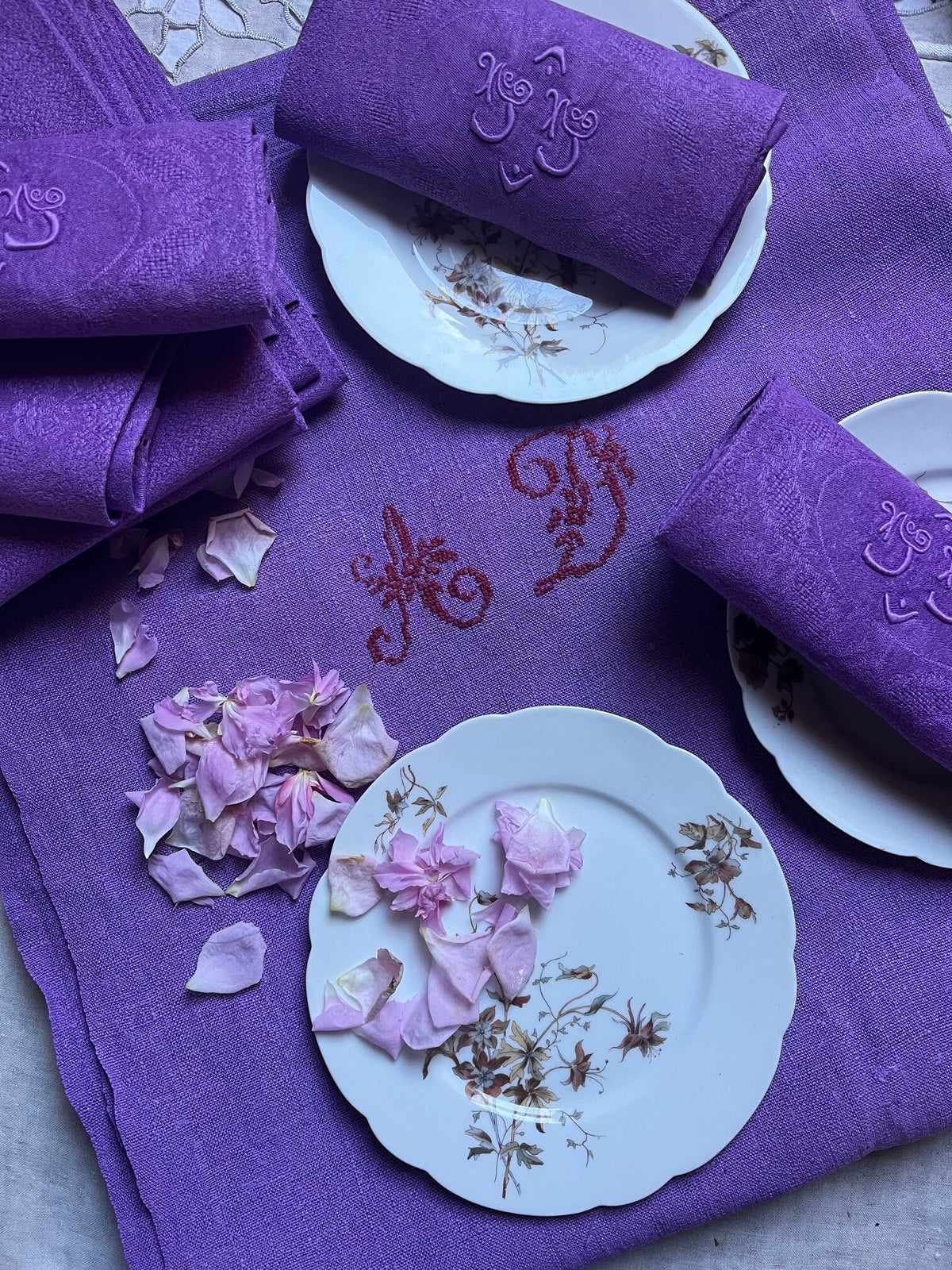 Détail d'un monogramme brodé sur une serviette de table ancienne lilas
