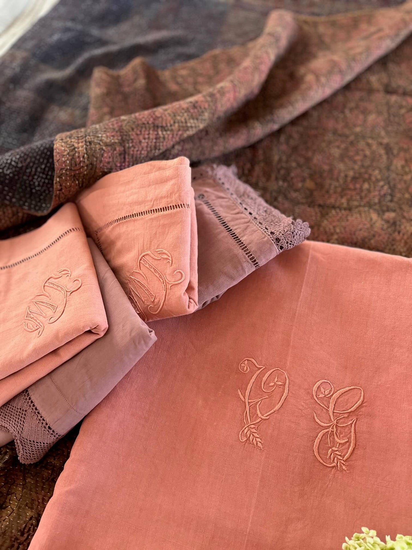 Détail des broderies et monogrammes d'un drap ancien français en lin teint terracotta.