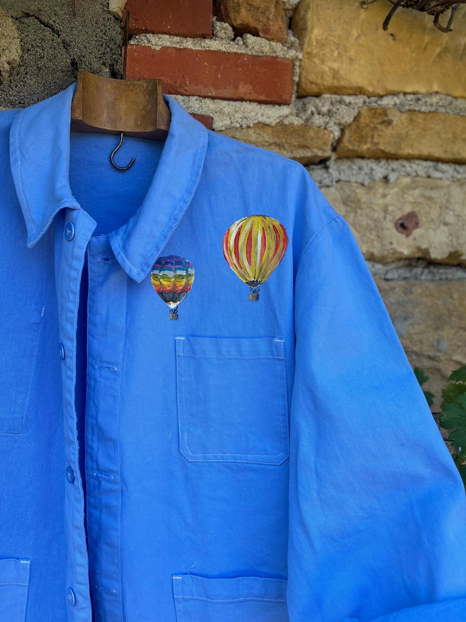 Détail des montgolfières peintes à la main sur un bleu de travail vintage français
