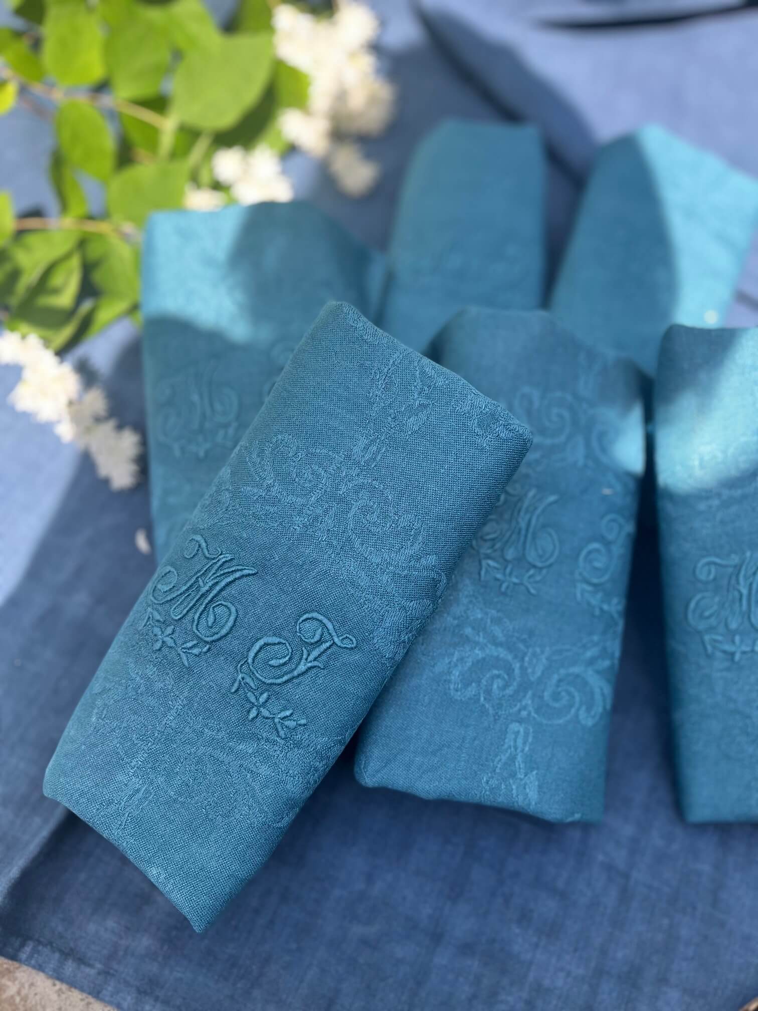 Détail d'une serviette ancienne damassée avec monogramme MT teinte bleu canard