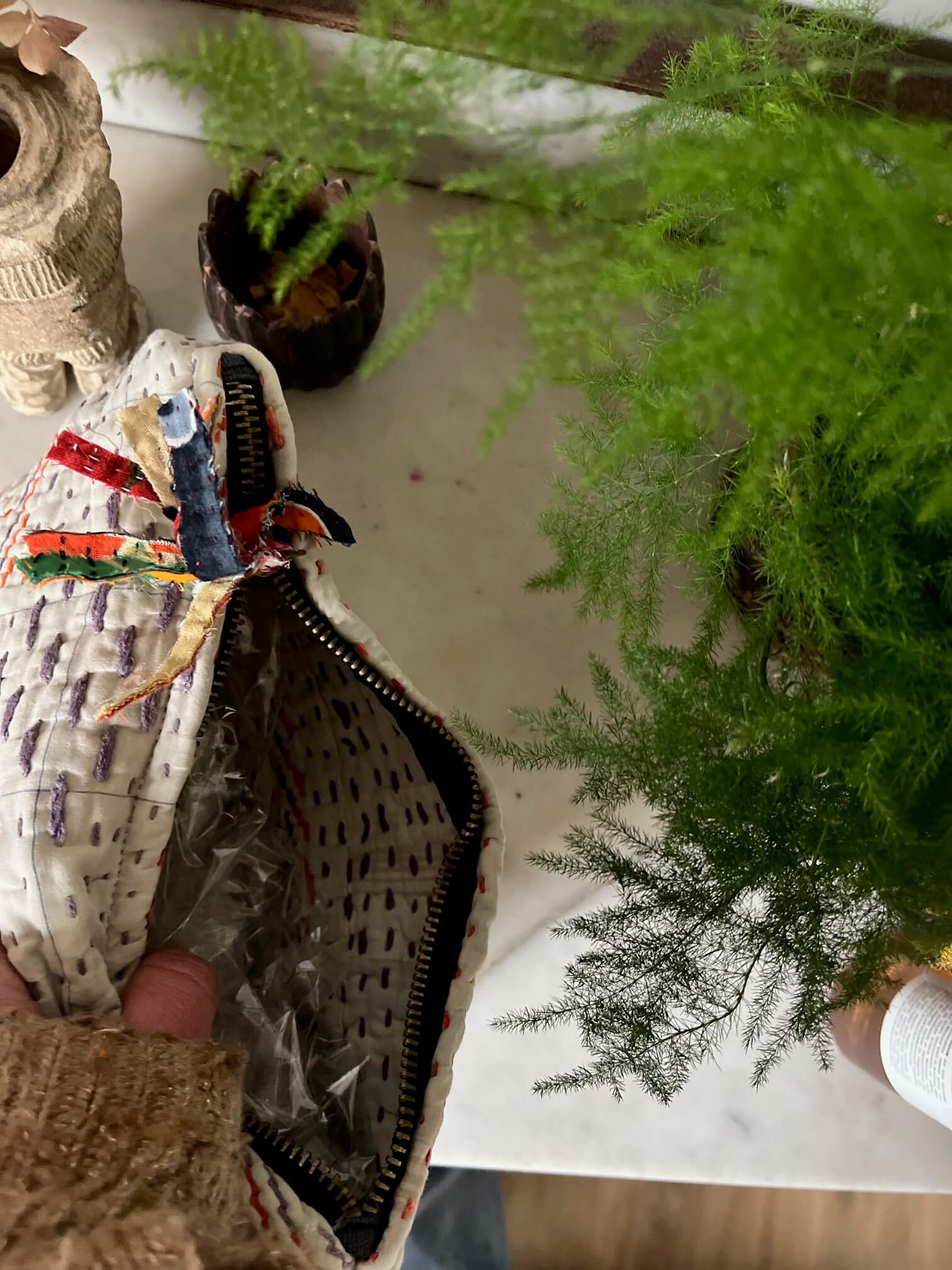 details de la pochette avec pompon en tissu