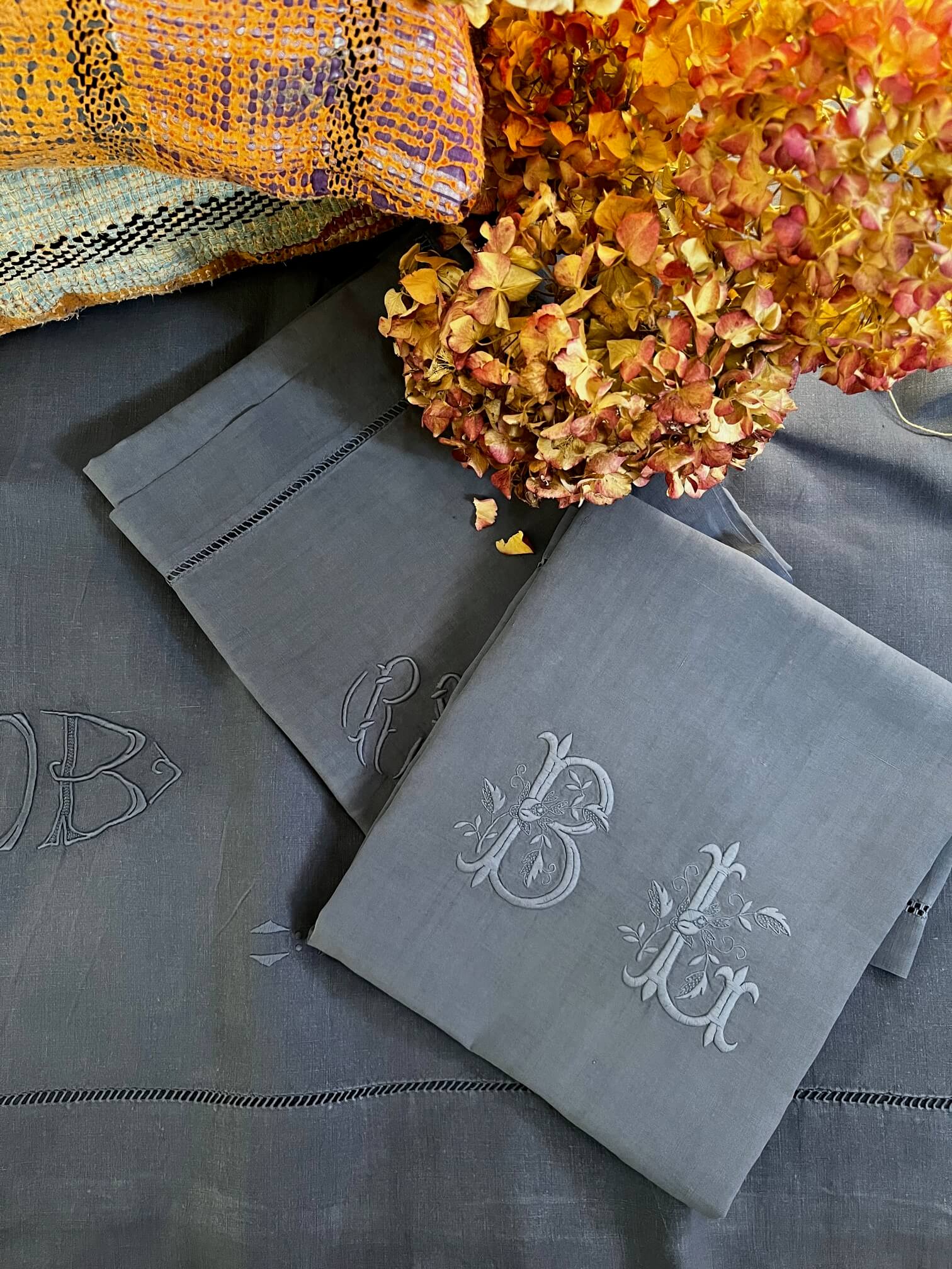 Détail broderie et monogrammes sur drap ancien bleu jeans