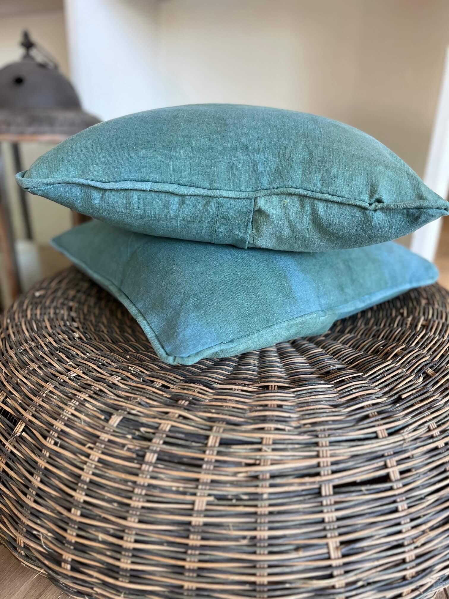 Housse de coussin turquoise en lin tie dye dans salon bohème chic avec canapé et déco vintage