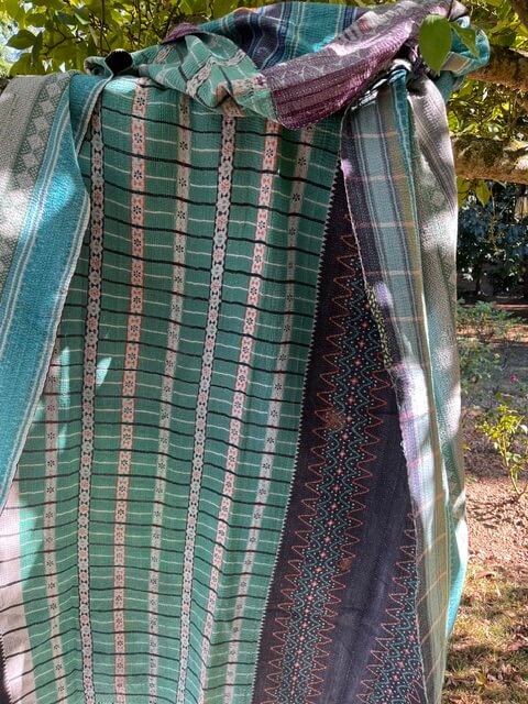Kantha indien réversible bleu, vert et prune mis en scène dans une décoration bohème chic.