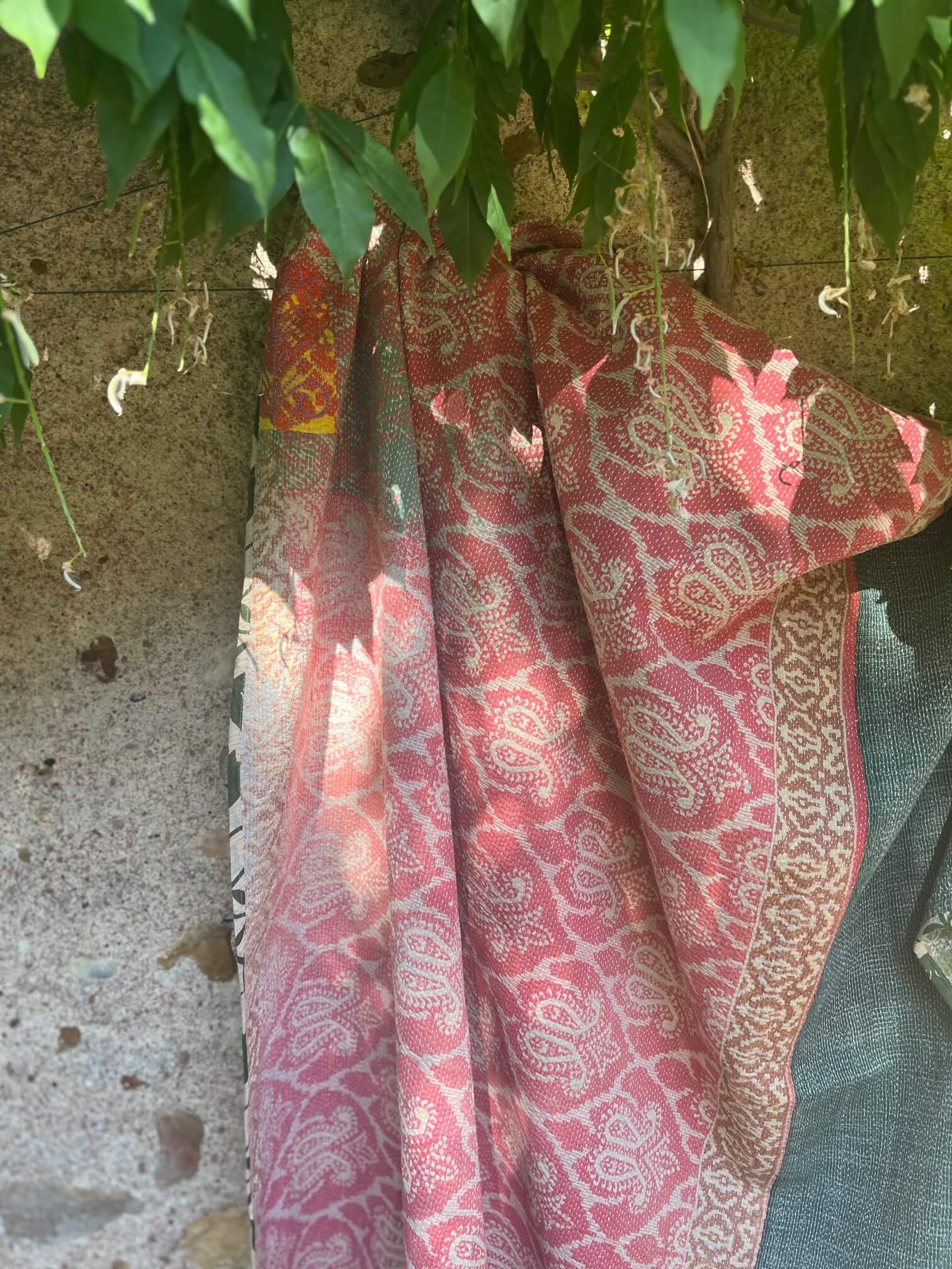 Kantha indien réversible fait main rose poudré et vert sauge suspendu sous un arbre