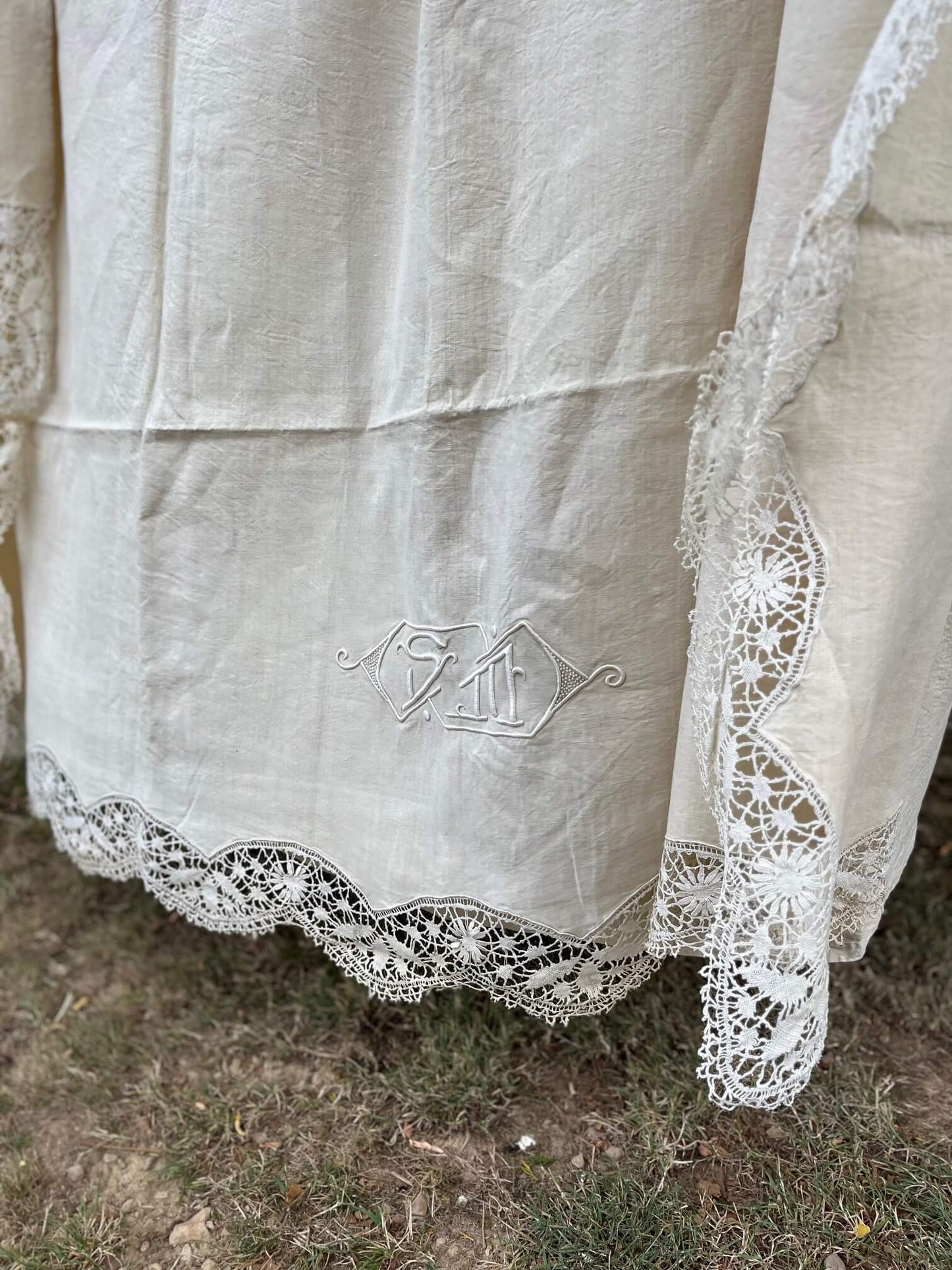 Drap ancien en lin beige présenté dans une ambiance de chambre vintage