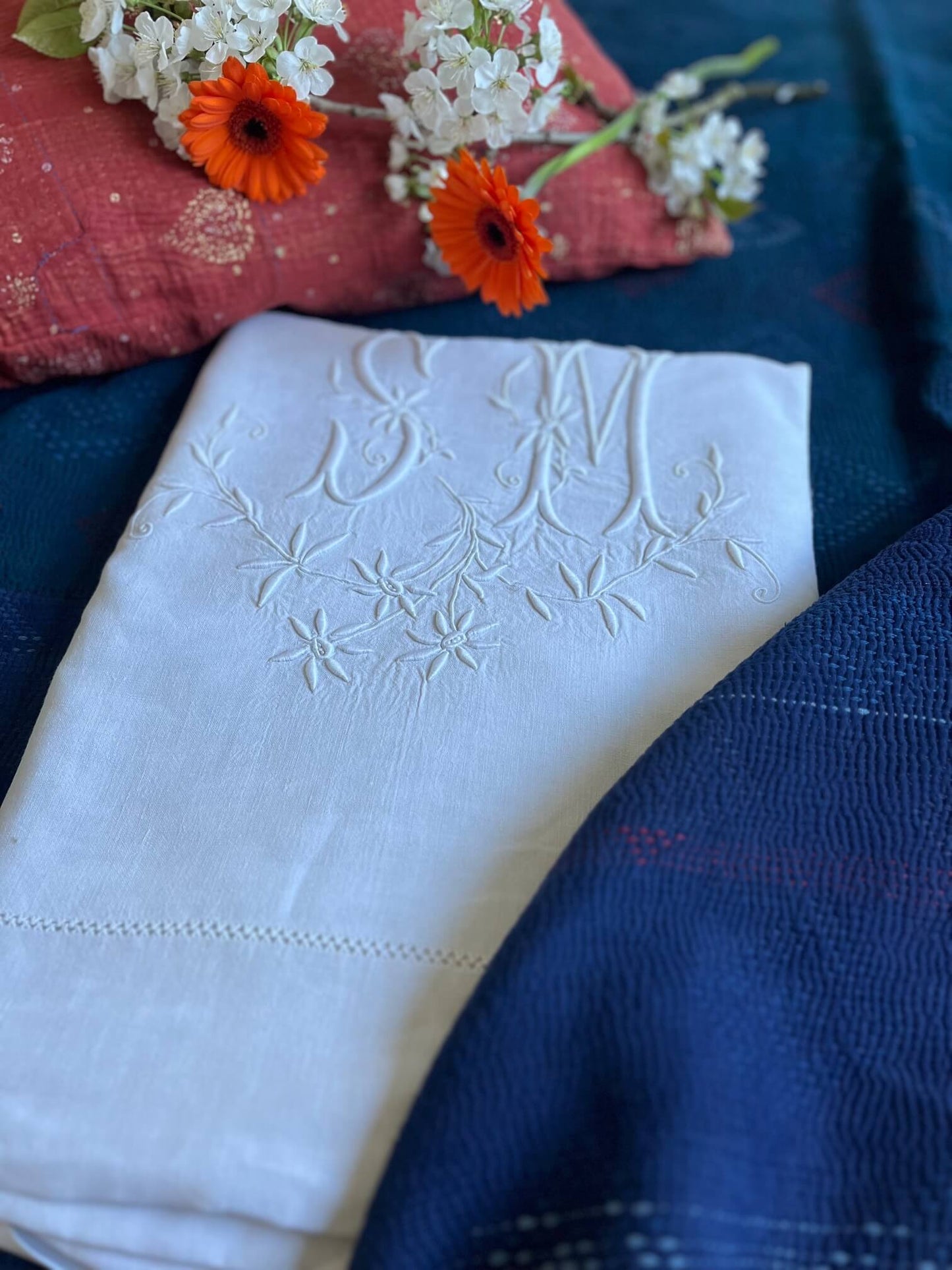Zoom sur broderie florale monogrammée SM sur drap ancien, linge blanc revalorisé avec touche bohème