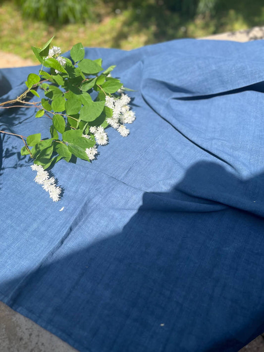 Nappe ancienne en linge ancien français teinte bleu nuit présentée en extérieur avec fleurs blanches