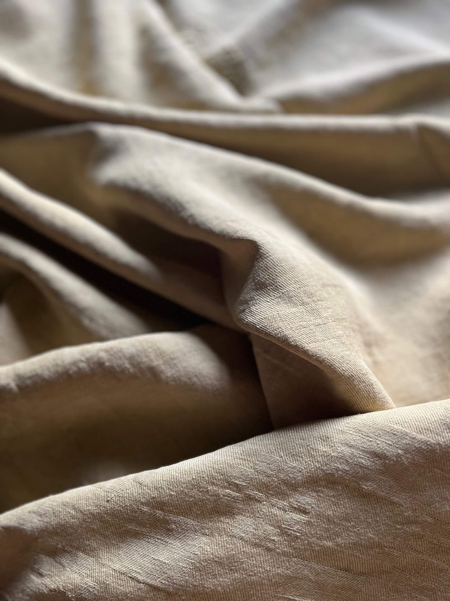 Gros plan sur le coton ancien de la nappe ocre, détails du tissage et texture artisanale