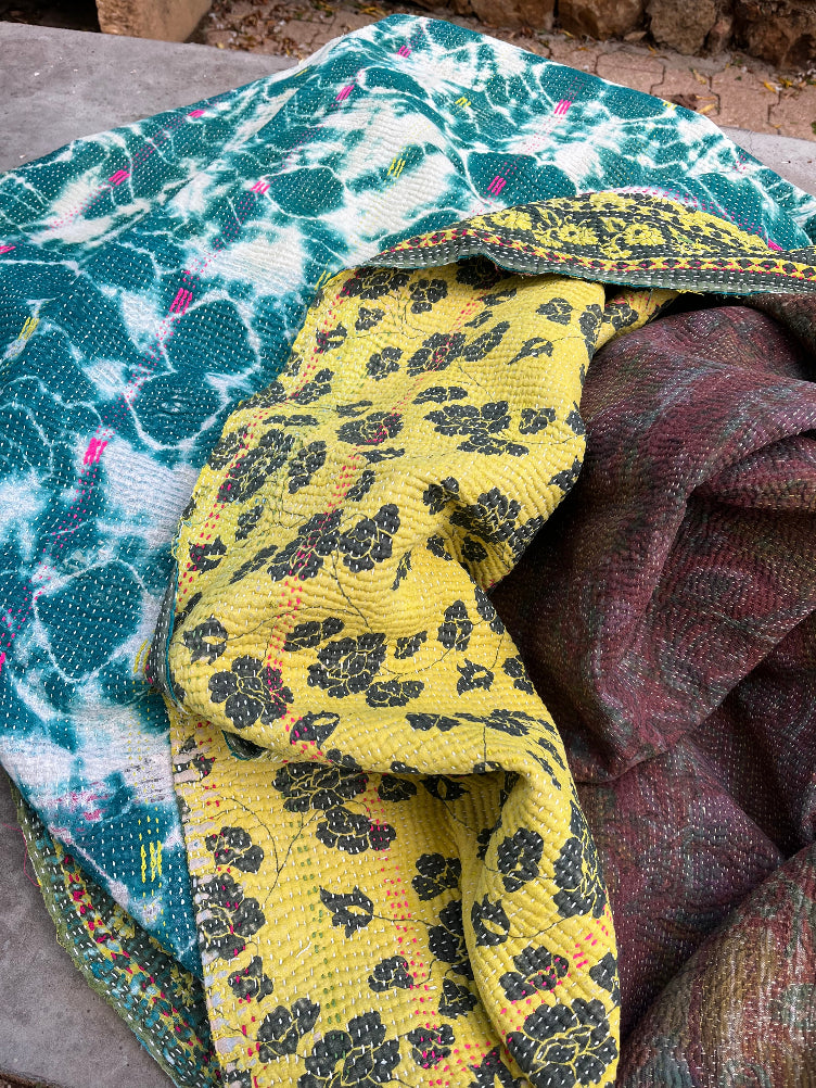 Plaid kantha indien bohème en coton suspendu dans un jardin