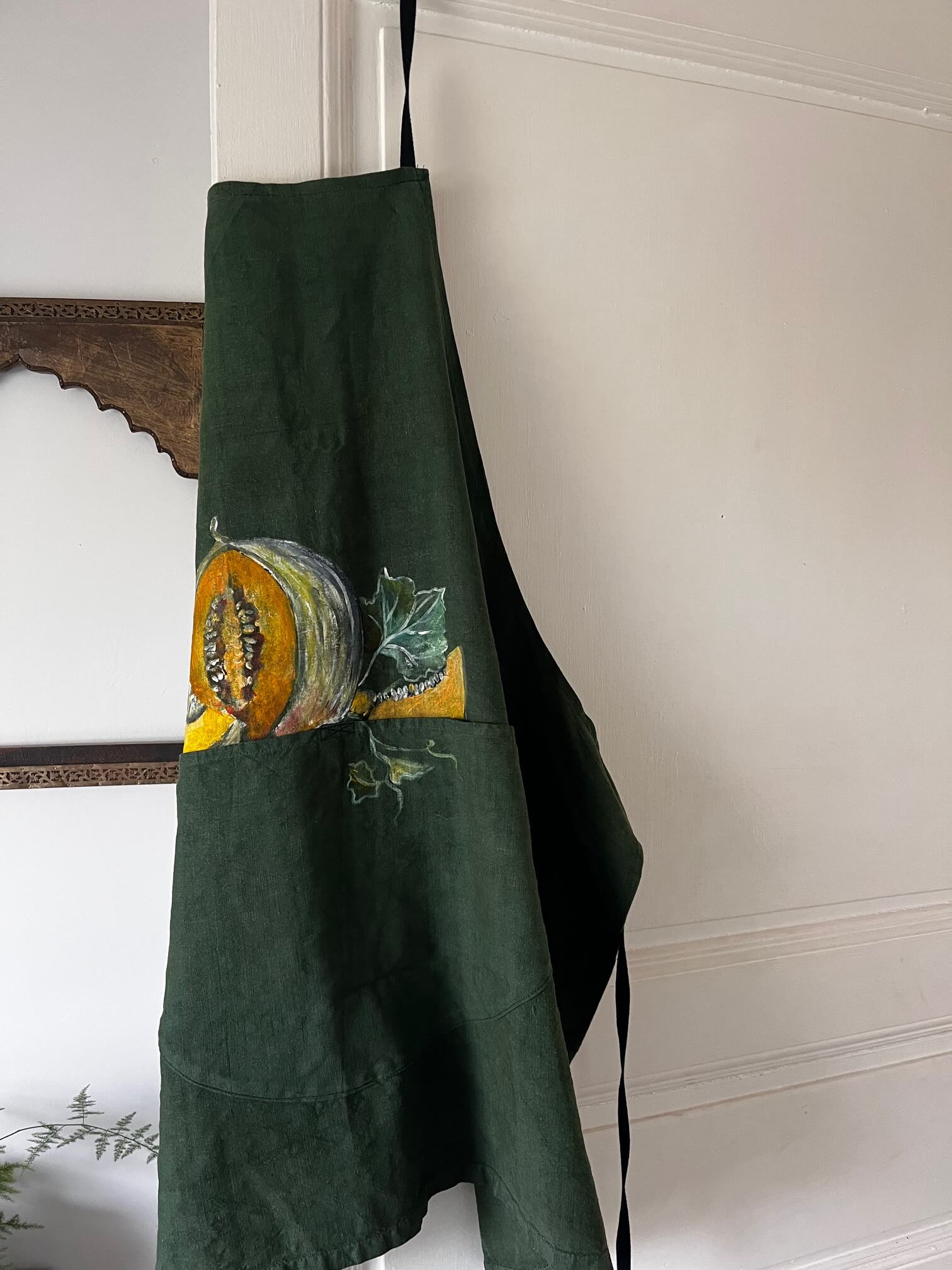Détail du tablier artisanal vert avec motifs peints