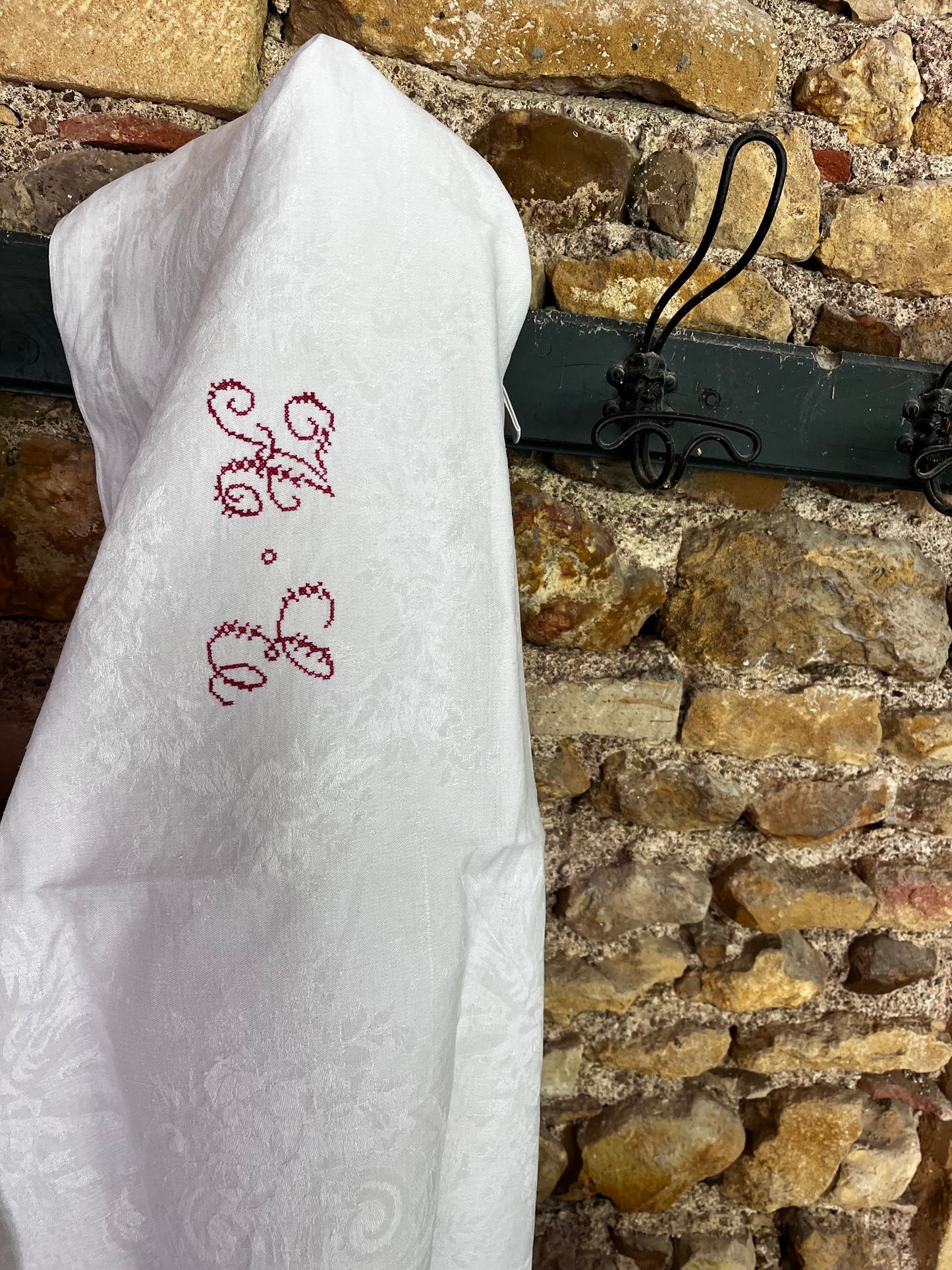 Torchon ancien monogrammé en coton damassé suspendu dans une cuisine de campagne