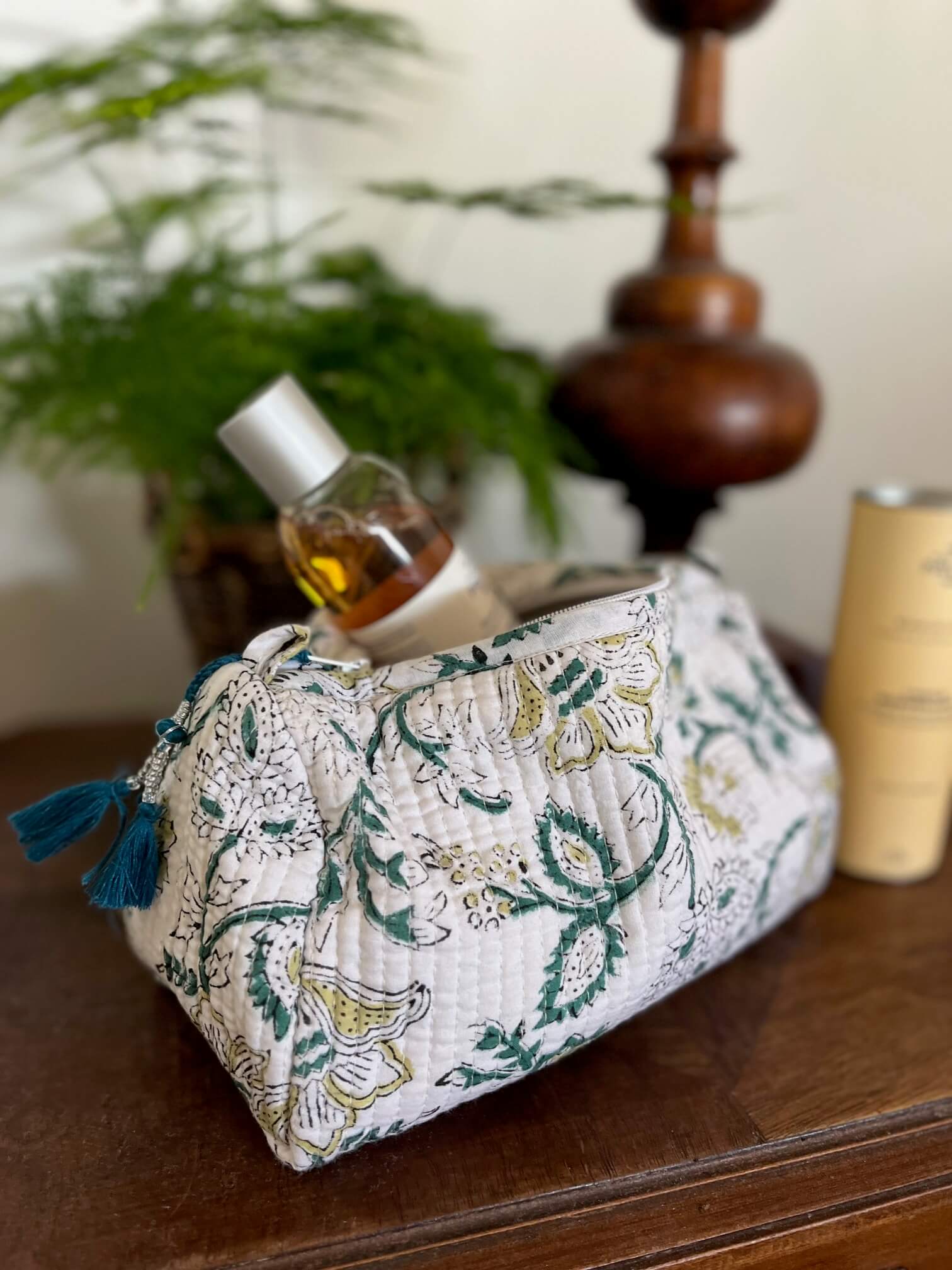 Trousse de toilette fleurie blanche en coton utilisée dans une salle de bain moderne – accessoire pratique et chic