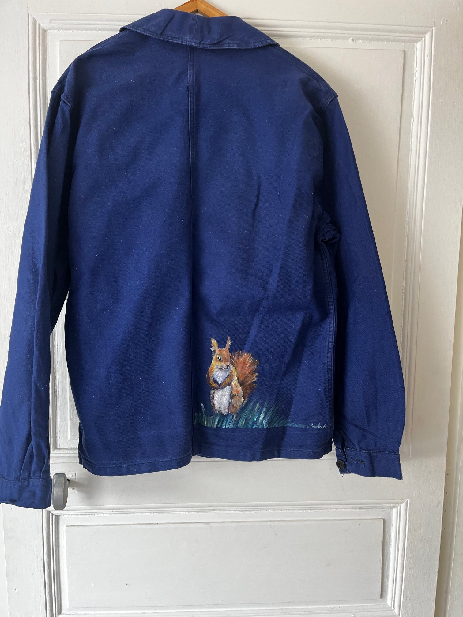Vue arrière du bleu de travail français vintage transformé en art textile avec écureuil