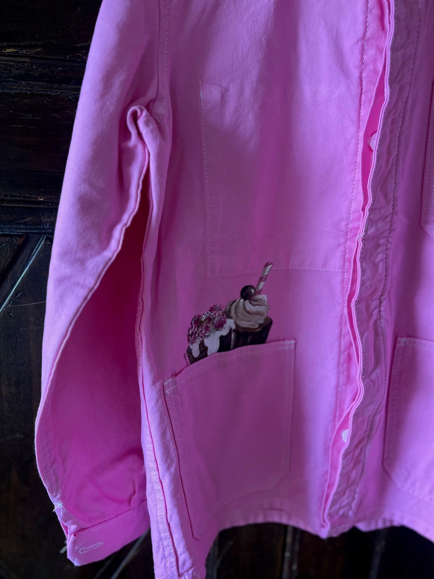 Détail de poche avec cupcakes peints à la main sur veste en coton rose – création originale et vintage